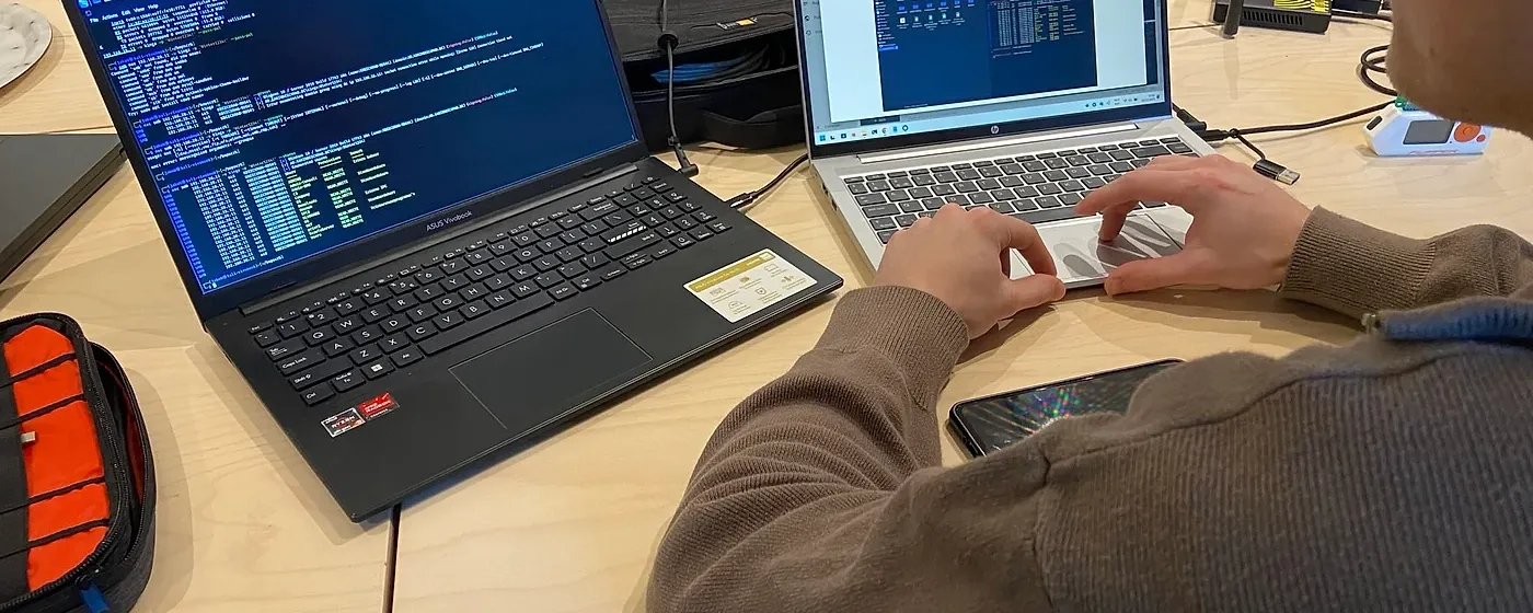 Safebyte pentester werkt op twee laptops tijdens een ethische hackingopdracht