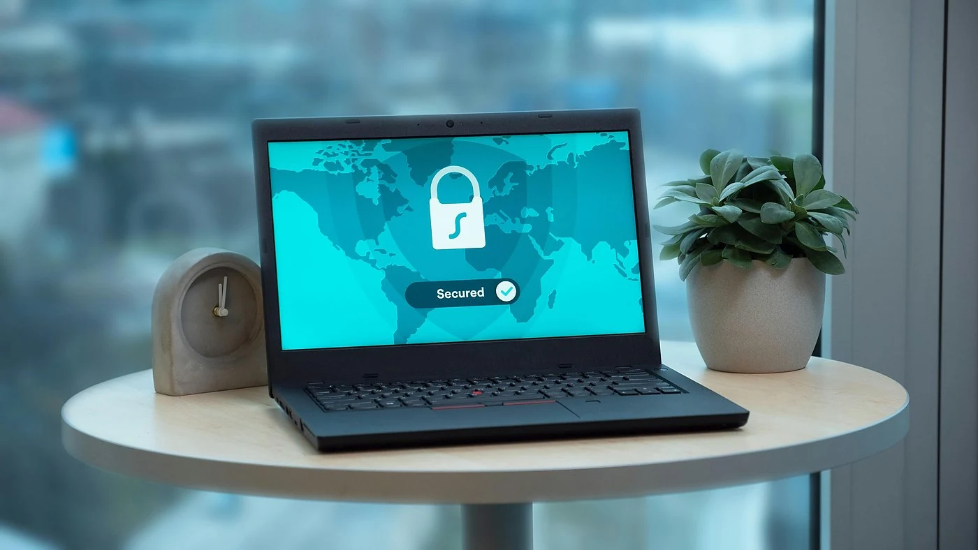 Laptop op tafel toont beveiligd VPN-scherm met hangslot, illustratie van tweestaps verificatie