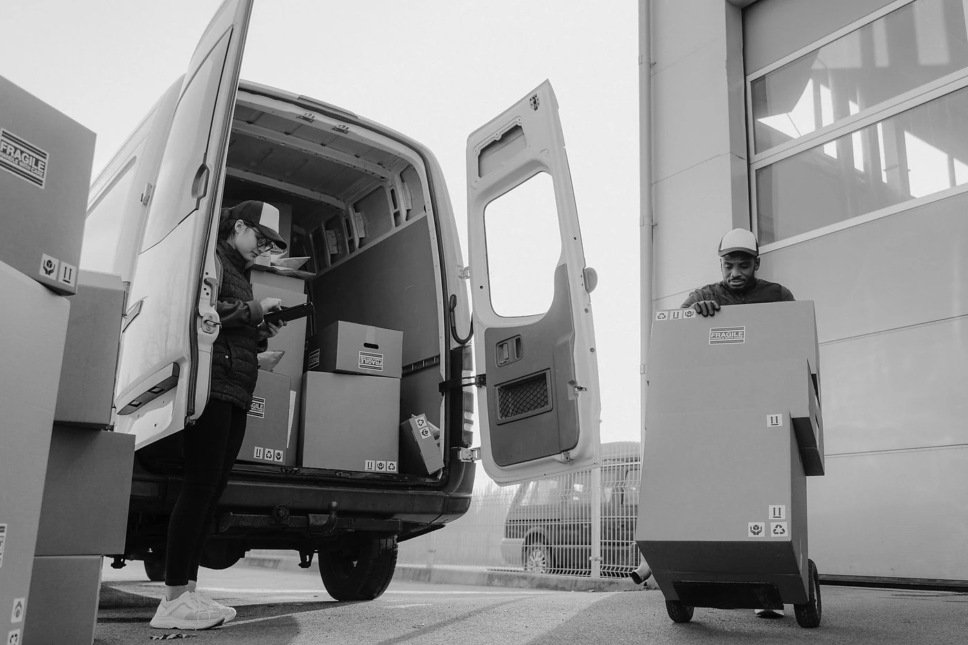 Bezorgers laden pakketten in een bestelwagen, illustratie van leveranciersrisico bij een supply chain aanval